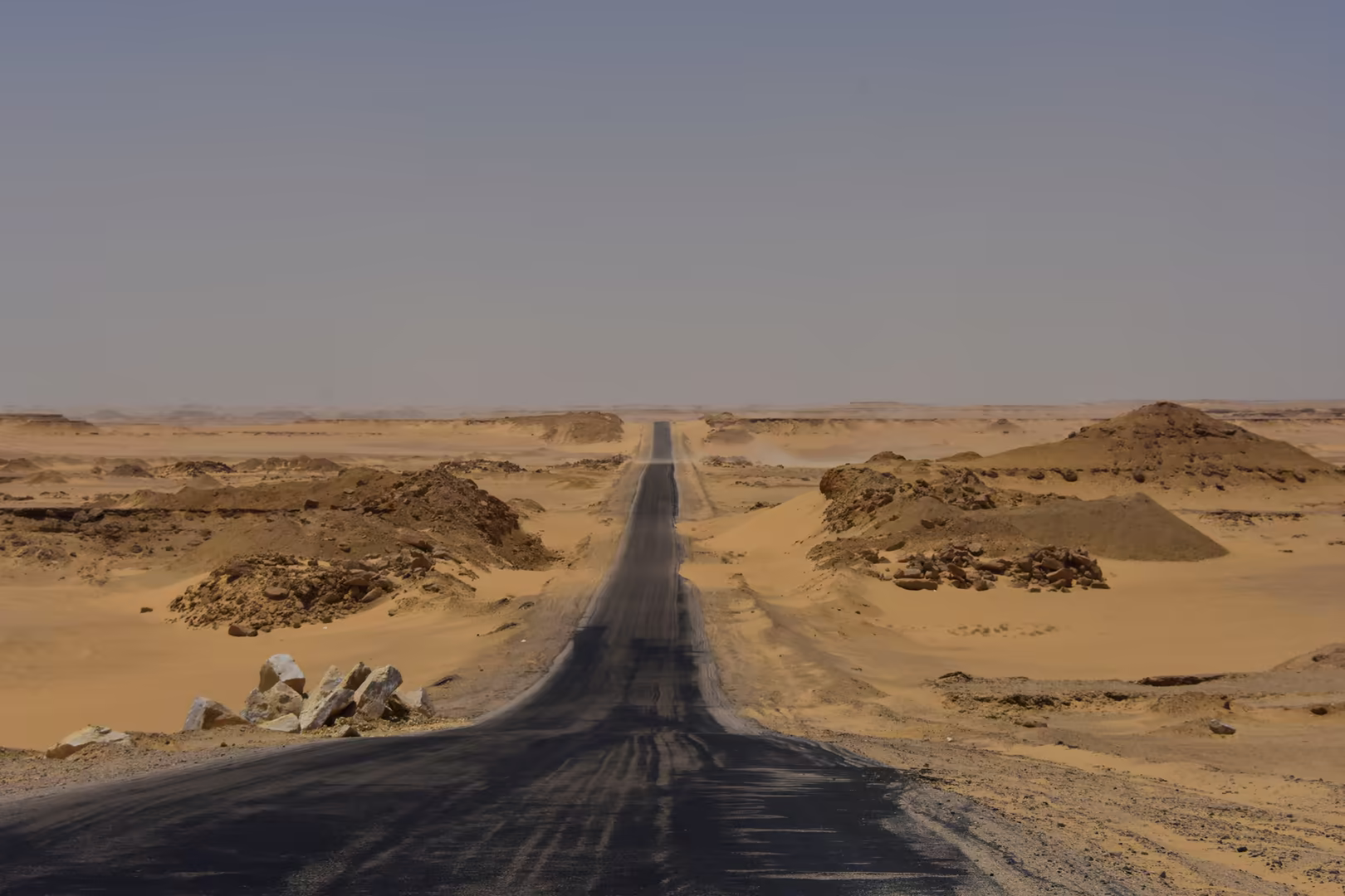 Die Straße durch die Wüste, schnurgerade bis an den dunstigen Horizont.