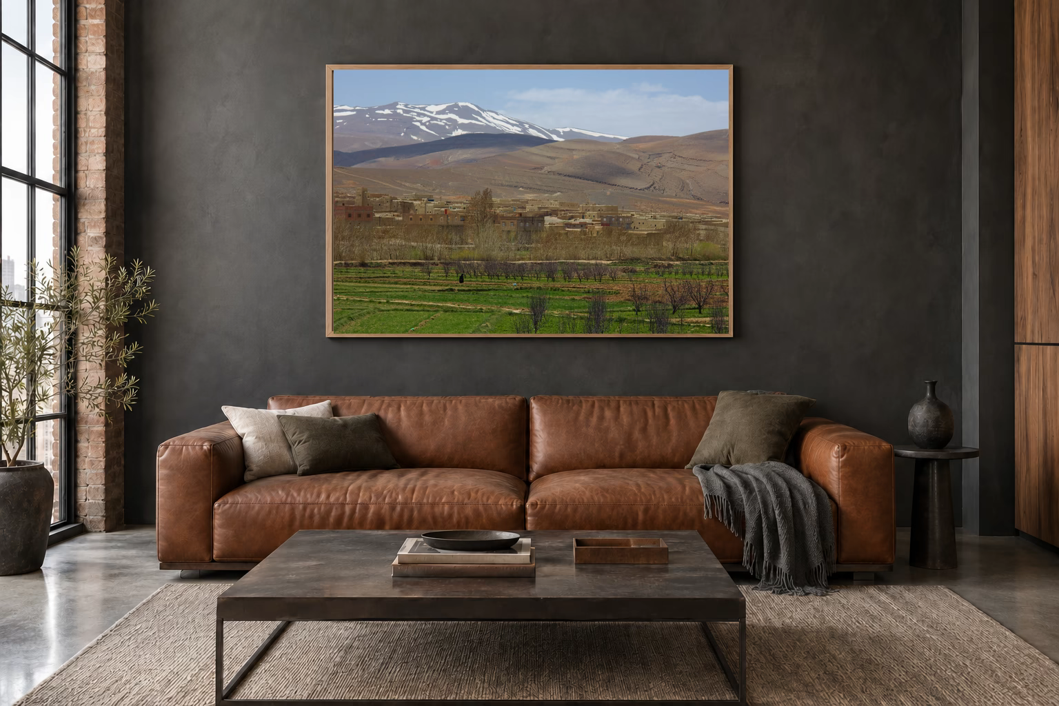 Das Werk an einer dunklen Wand im Loft über einem Ledersofa: Am Rand der Berge, 120 × 80 cm.