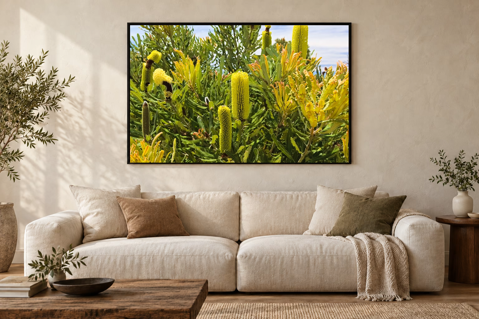 Das Werk an einer hellen Wohnzimmerwand über einem Sofa: Banksia im Küstenlicht im Rahmen, 120 × 80 cm.