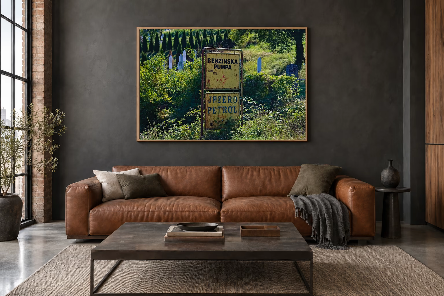 Das Werk an einer dunklen Wand im Loft über einem Ledersofa: Tankstellenschild im Wildwuchs, 120 × 80 cm.