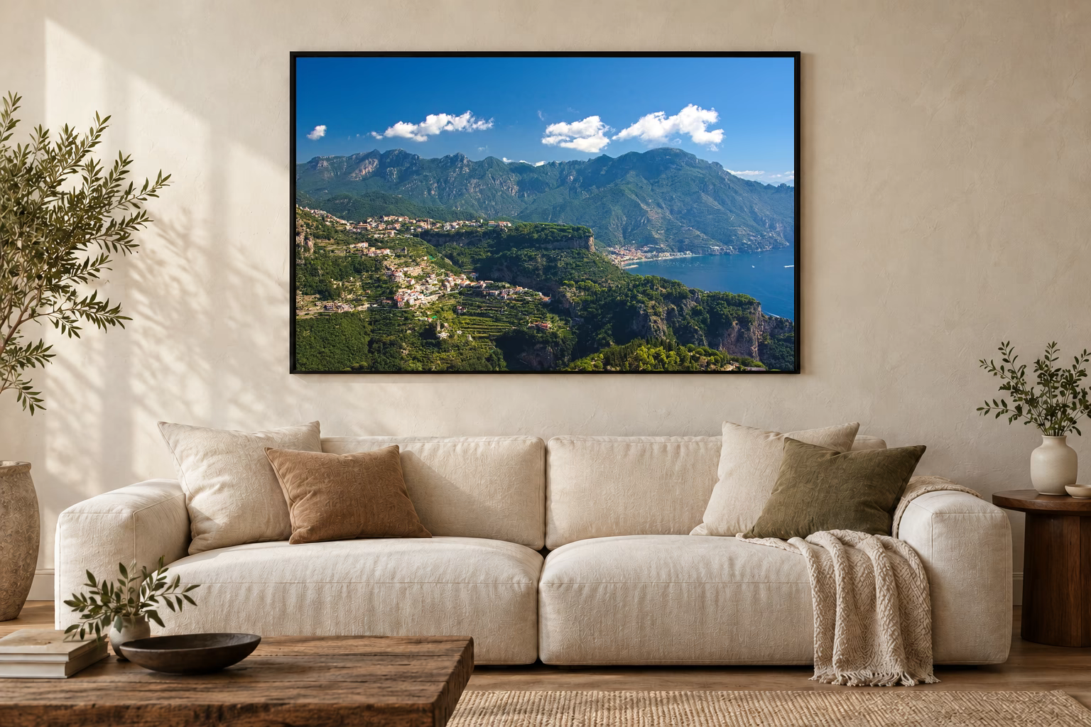 Das Werk an einer hellen Wohnzimmerwand über einem Sofa: Berglandschaft über der Amalfiküste im Rahmen, 120 × 80 cm.