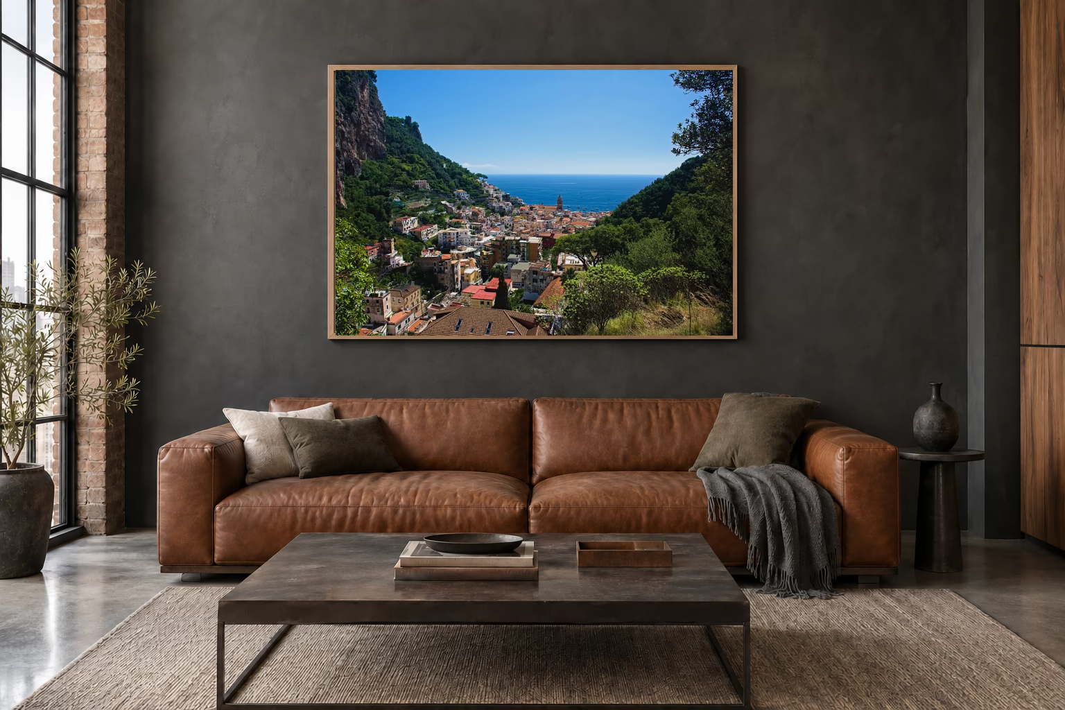 Das Werk an einer dunklen Wand im Loft über einem Ledersofa: Blick auf Amalfi, 120 × 80 cm.