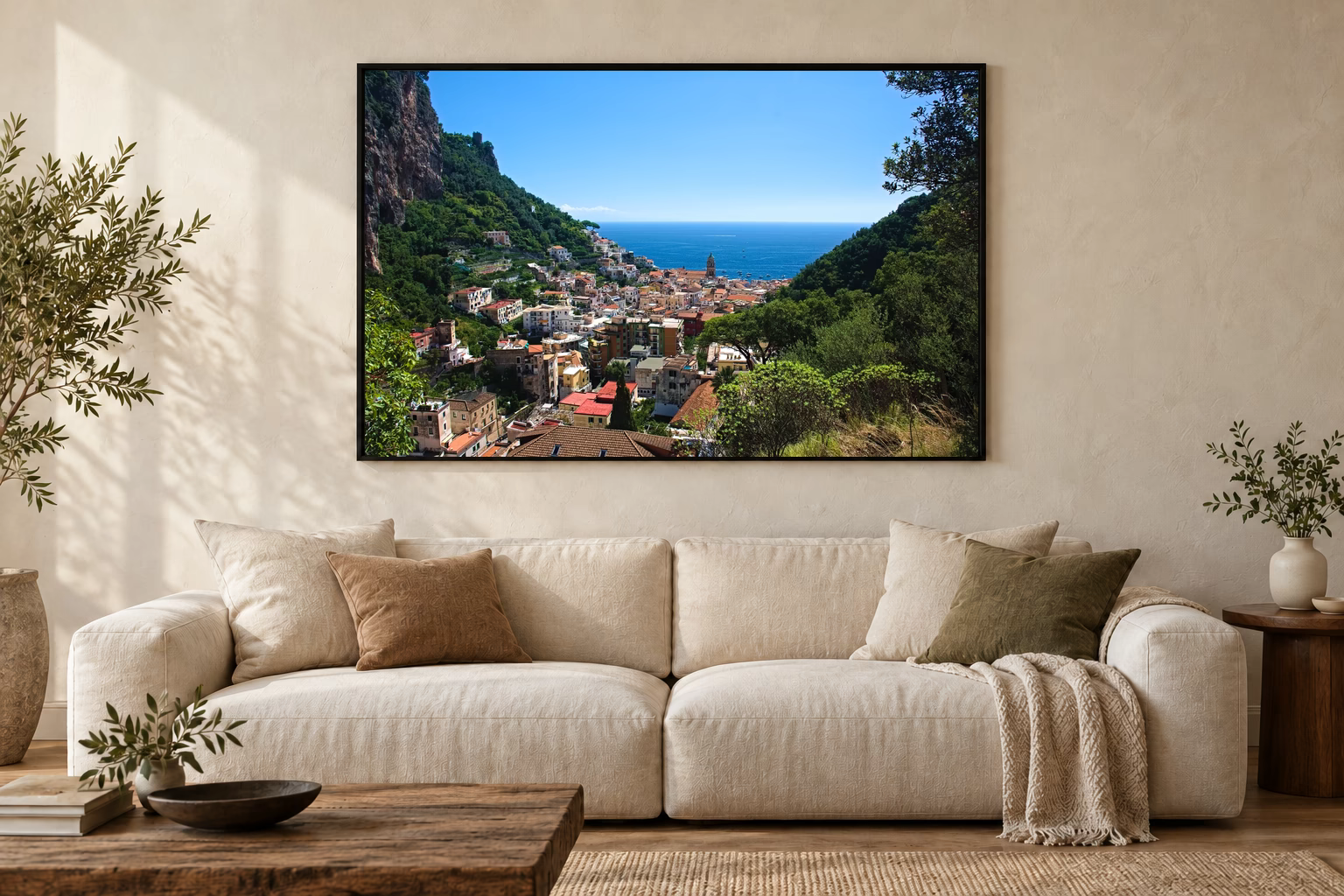Das Werk an einer hellen Wohnzimmerwand über einem Sofa: Blick auf Amalfi im Rahmen, 120 × 80 cm.
