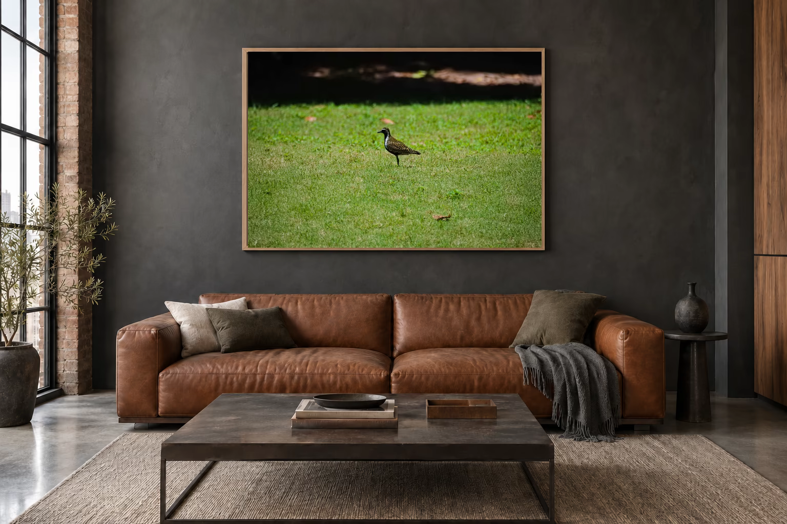 Das Werk an einer dunklen Wand im Loft über einem Ledersofa: Ein Vogel auf dem Rasen, 120 × 80 cm.