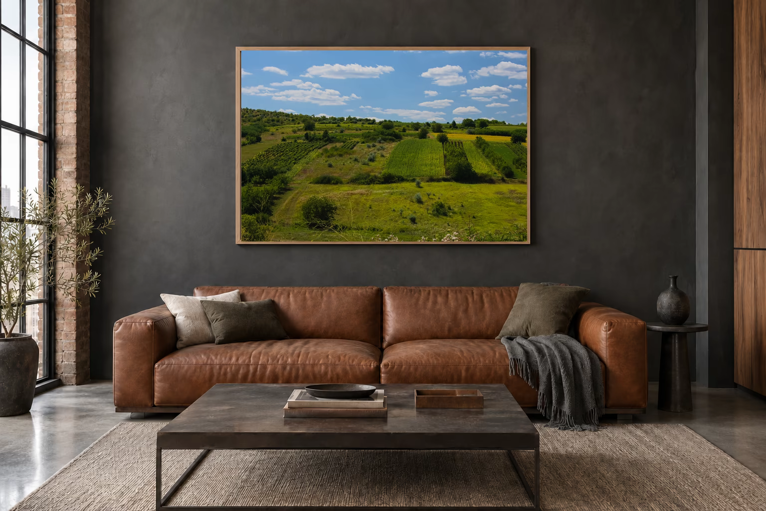 Das Werk an einer dunklen Wand im Loft über einem Ledersofa: Felder über den Hügeln, 120 × 80 cm.