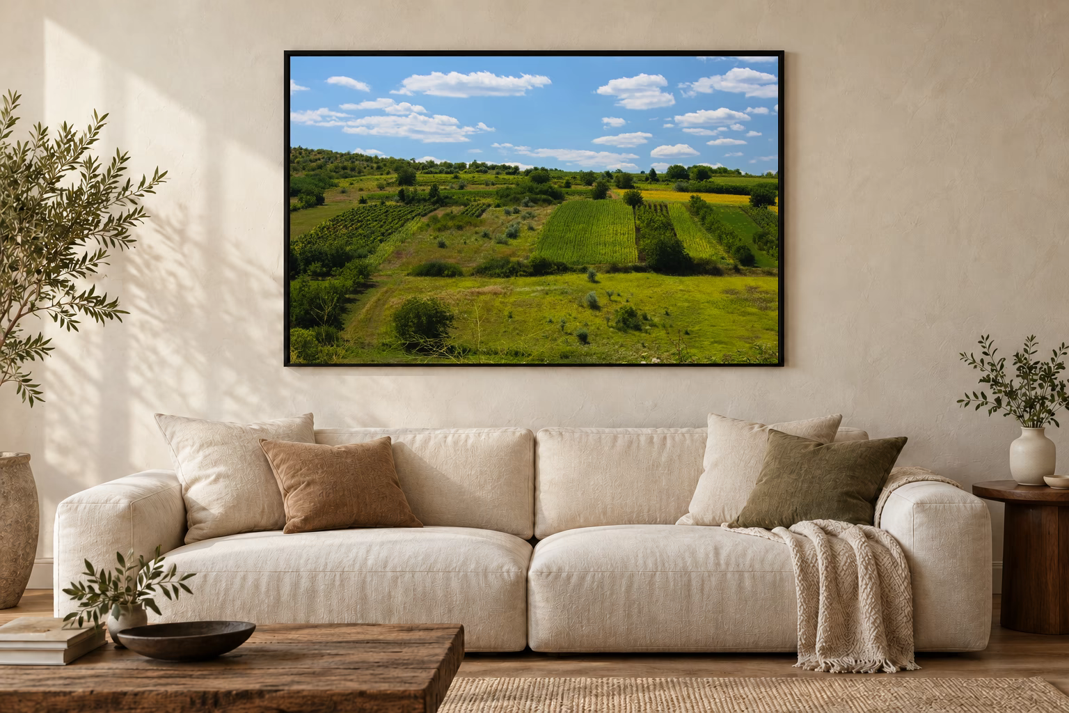 Das Werk an einer hellen Wohnzimmerwand über einem Sofa: Felder über den Hügeln im Rahmen, 120 × 80 cm.