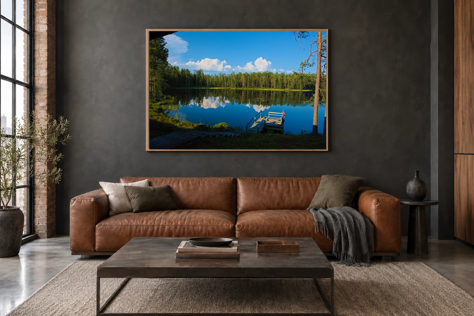 Das Werk an einer dunklen Wand im Loft über einem Ledersofa: Finnischer See mit Steg, 120 × 80 cm.