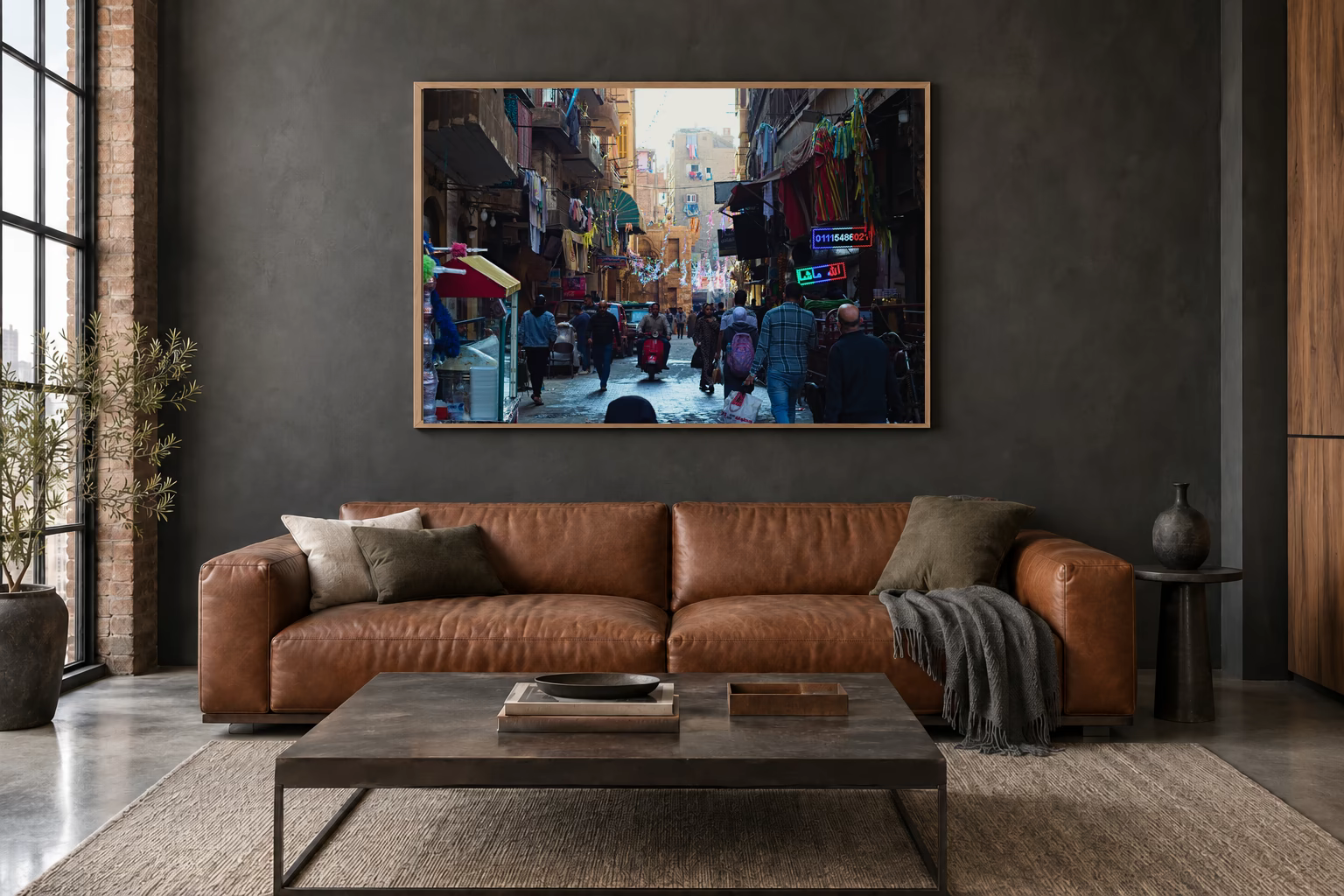 Das Werk an einer dunklen Wand im Loft über einem Ledersofa: Gasse mit Wäscheleinen, 120 × 80 cm.