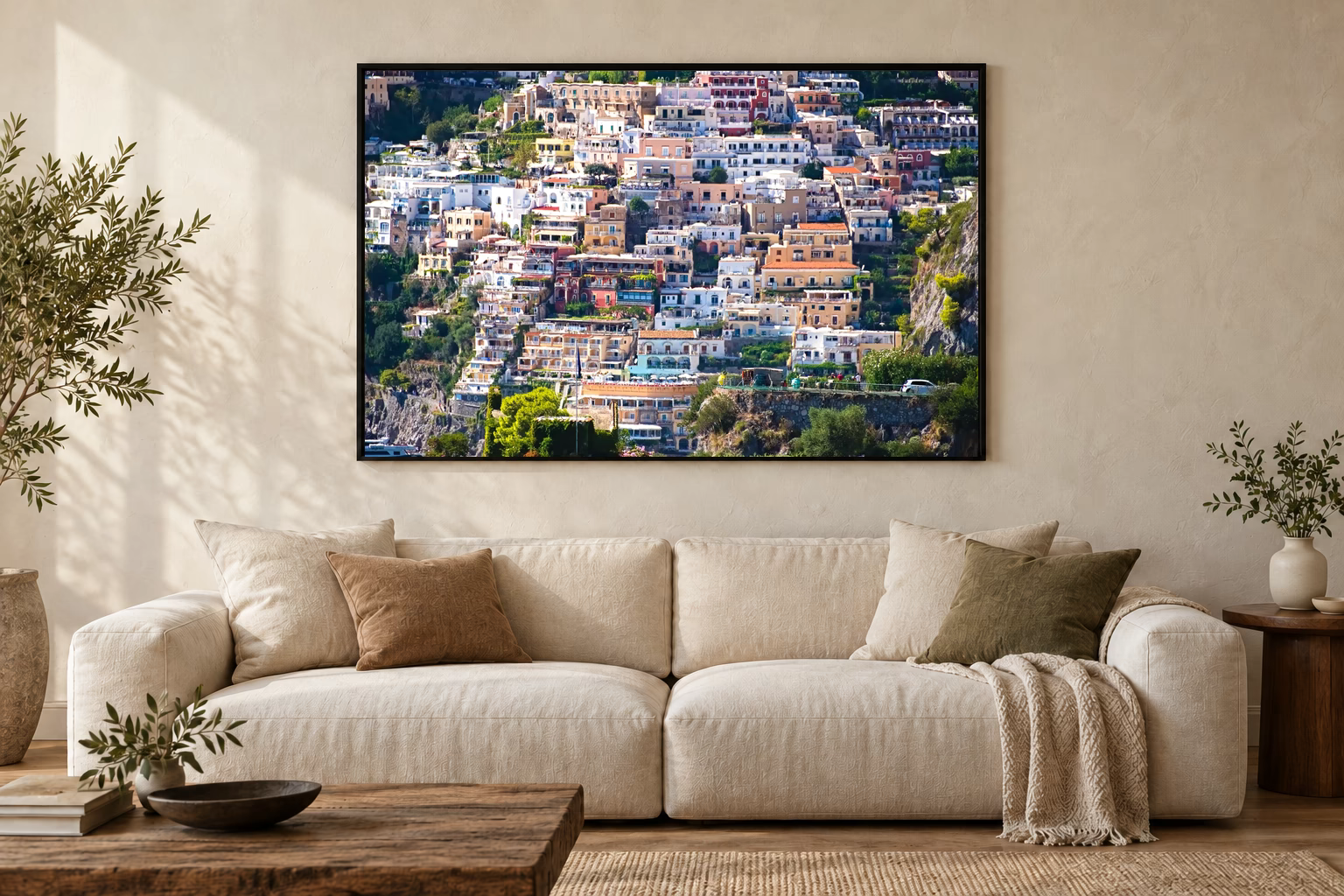 Das Werk an einer hellen Wohnzimmerwand über einem Sofa: Häusermeer von Positano im Rahmen, 120 × 80 cm.