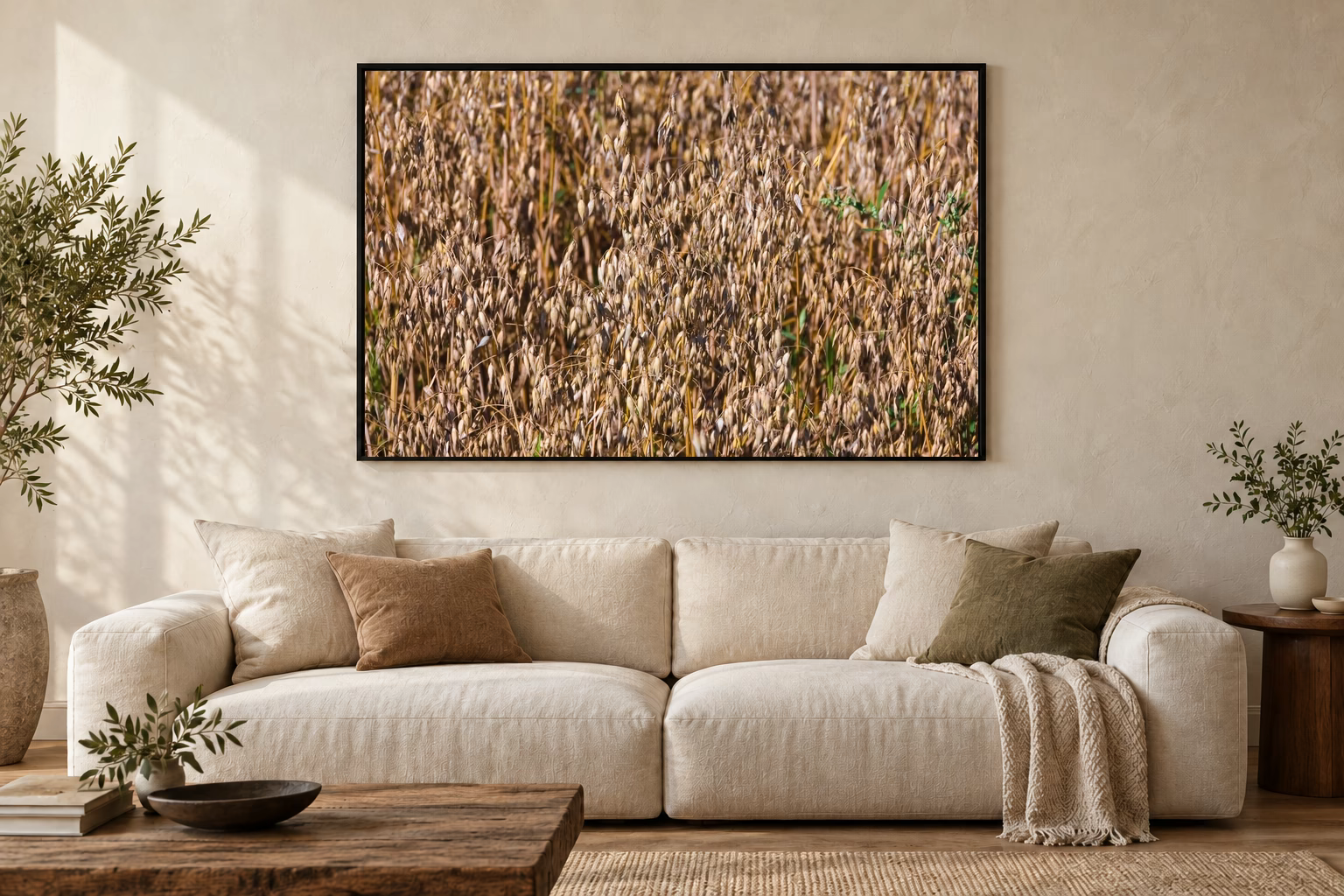 Das Werk an einer hellen Wohnzimmerwand über einem Sofa: Haferfeld im Morgenlicht im Rahmen, 120 × 80 cm.