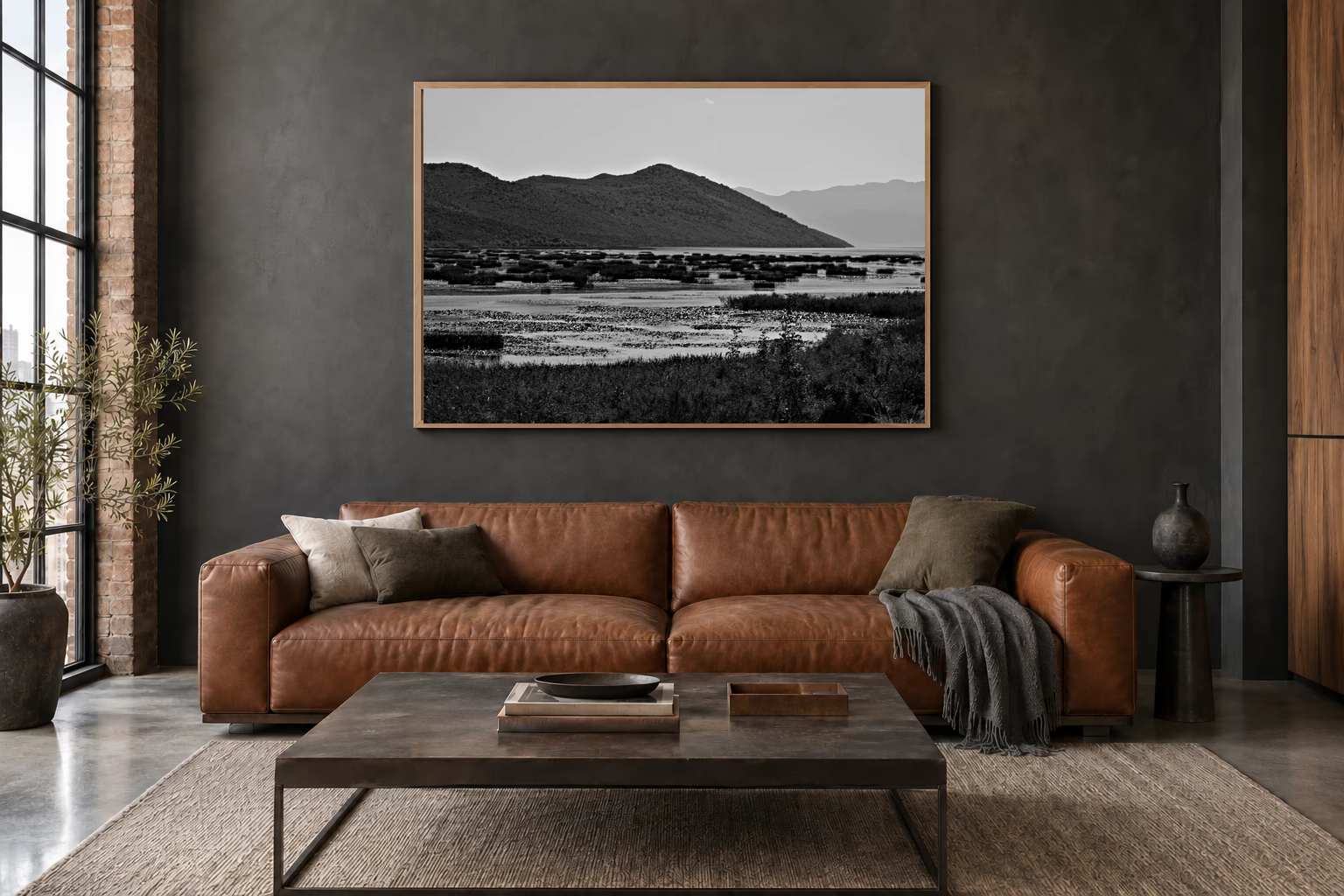 Das Werk an einer dunklen Wand im Loft über einem Ledersofa: Lagune am Bergfuß, 120 × 80 cm.