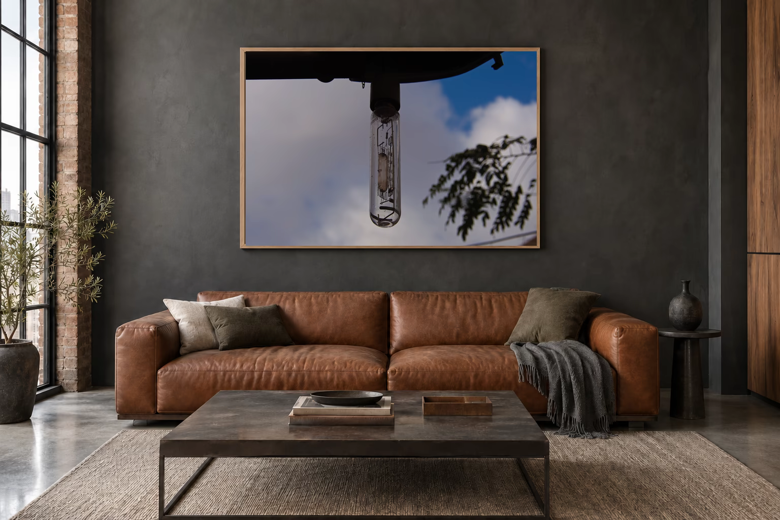 Das Werk an einer dunklen Wand im Loft über einem Ledersofa: Lampe vor blauem Himmel, 120 × 80 cm.