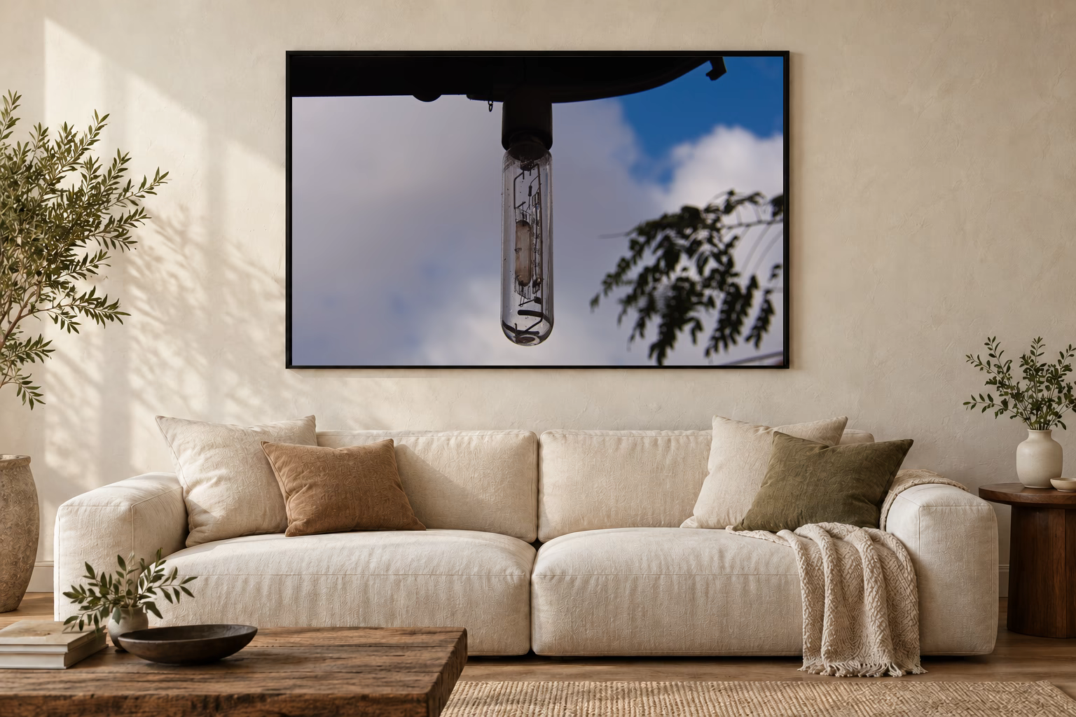 Das Werk an einer hellen Wohnzimmerwand über einem Sofa: Lampe vor blauem Himmel im Rahmen, 120 × 80 cm.