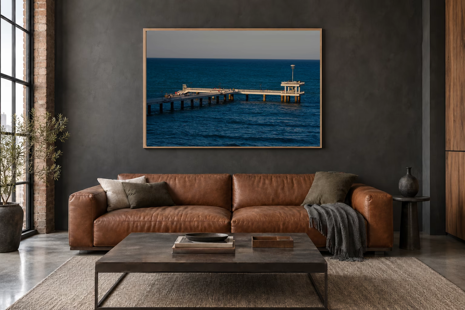 Das Werk an einer dunklen Wand im Loft über einem Ledersofa: Letztes Licht am Brückenkopf, 120 × 80 cm.