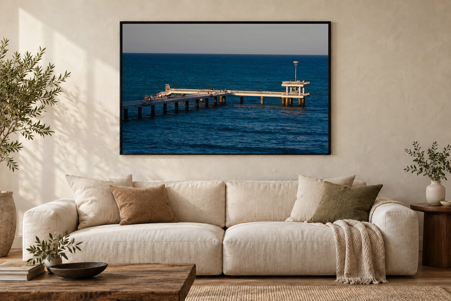 Das Werk an einer hellen Wohnzimmerwand über einem Sofa: Letztes Licht am Brückenkopf im Rahmen, 120 × 80 cm.