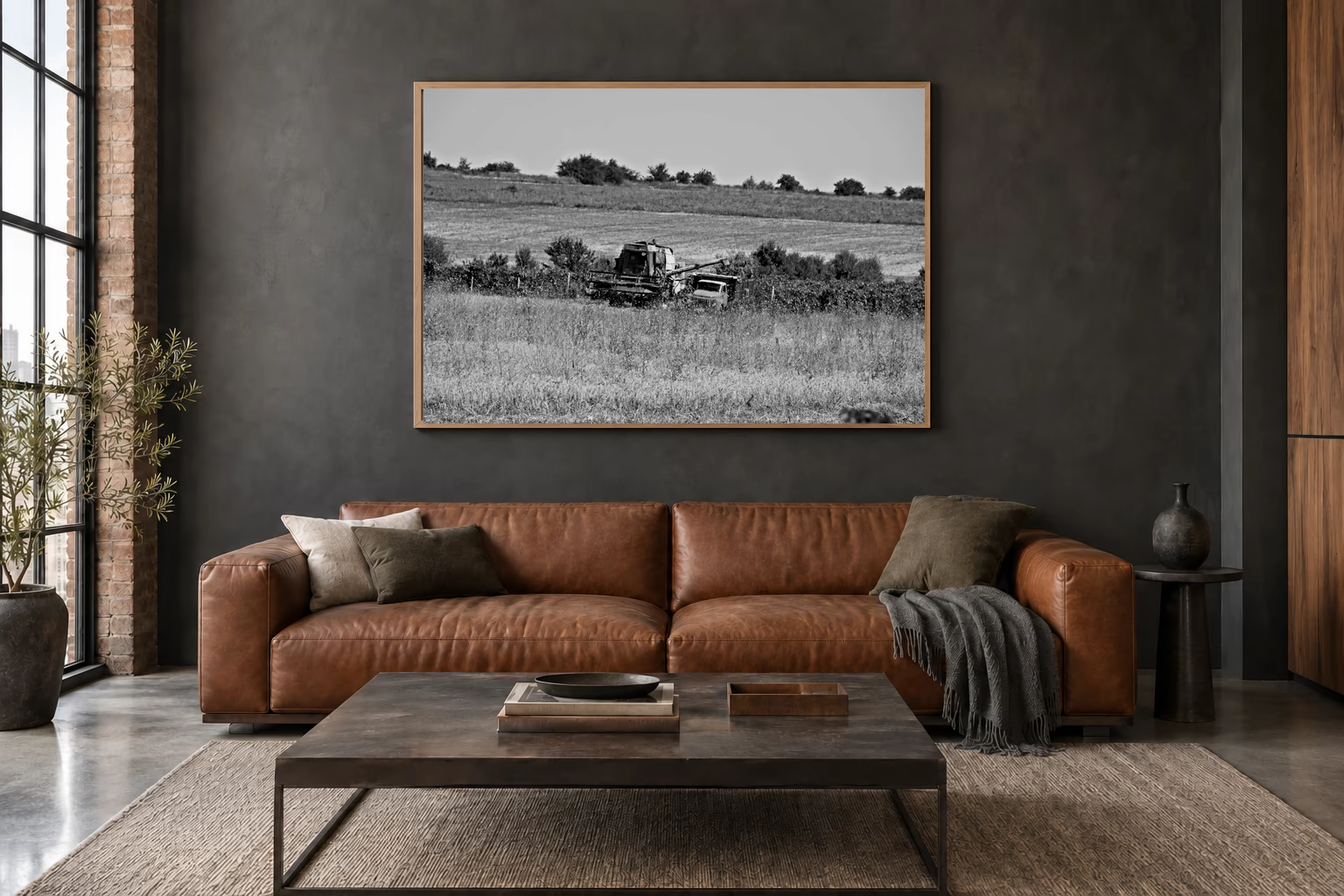 Das Werk an einer dunklen Wand im Loft über einem Ledersofa: Mähdrescher und Lastwagen, 120 × 80 cm.