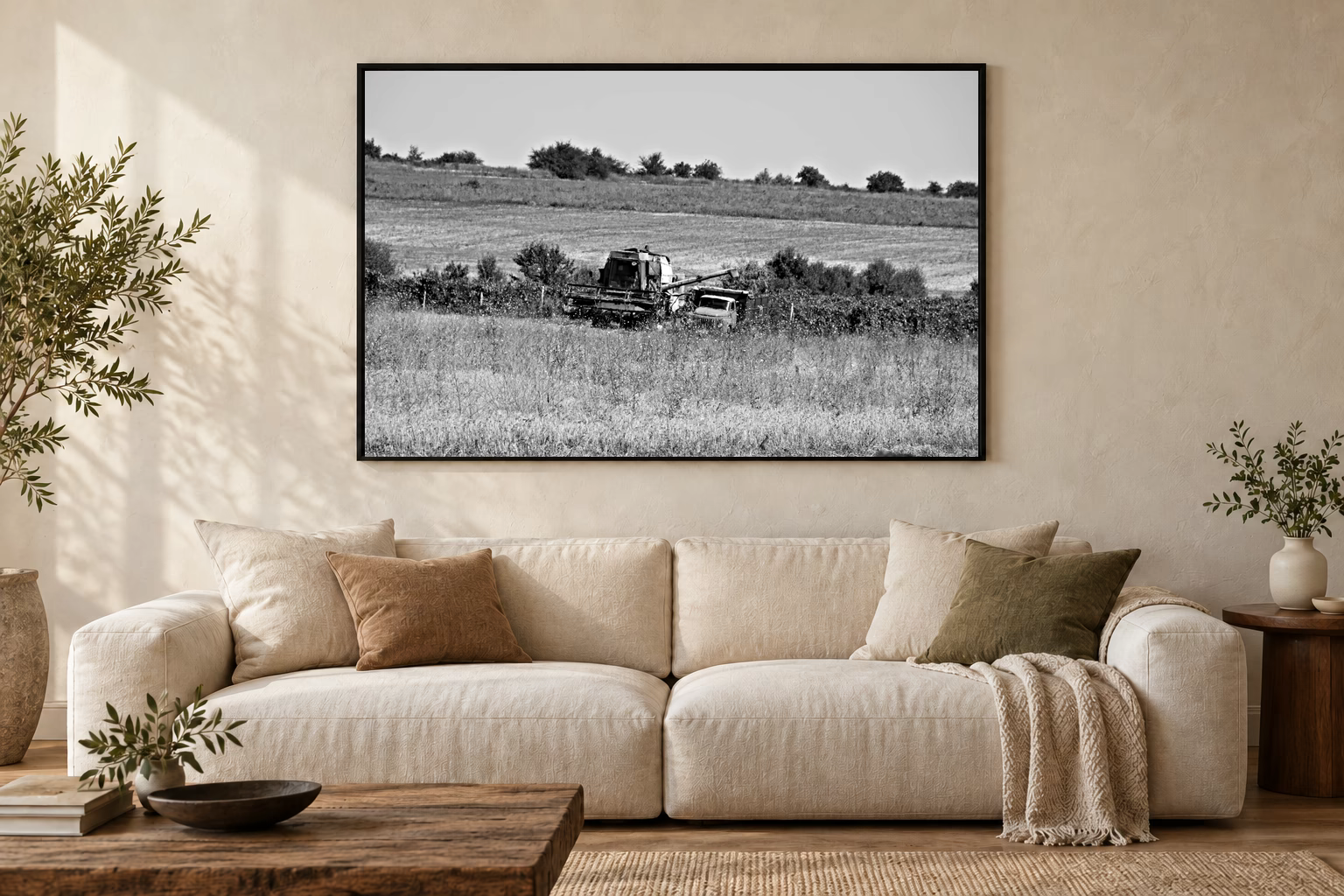 Das Werk an einer hellen Wohnzimmerwand über einem Sofa: Mähdrescher und Lastwagen im Rahmen, 120 × 80 cm.