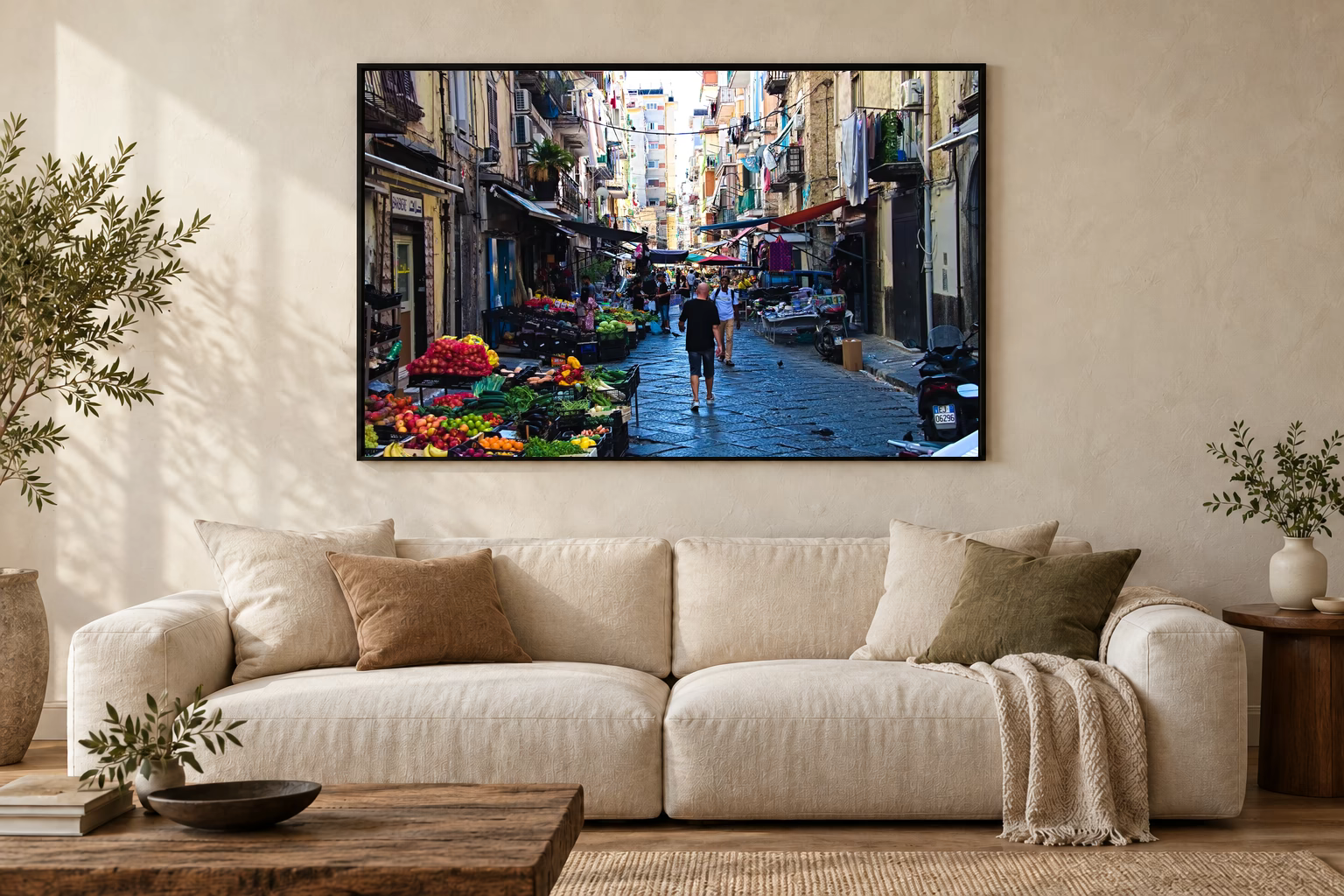 Das Werk an einer hellen Wohnzimmerwand über einem Sofa: Marktgasse in Neapel im Rahmen, 120 × 80 cm.