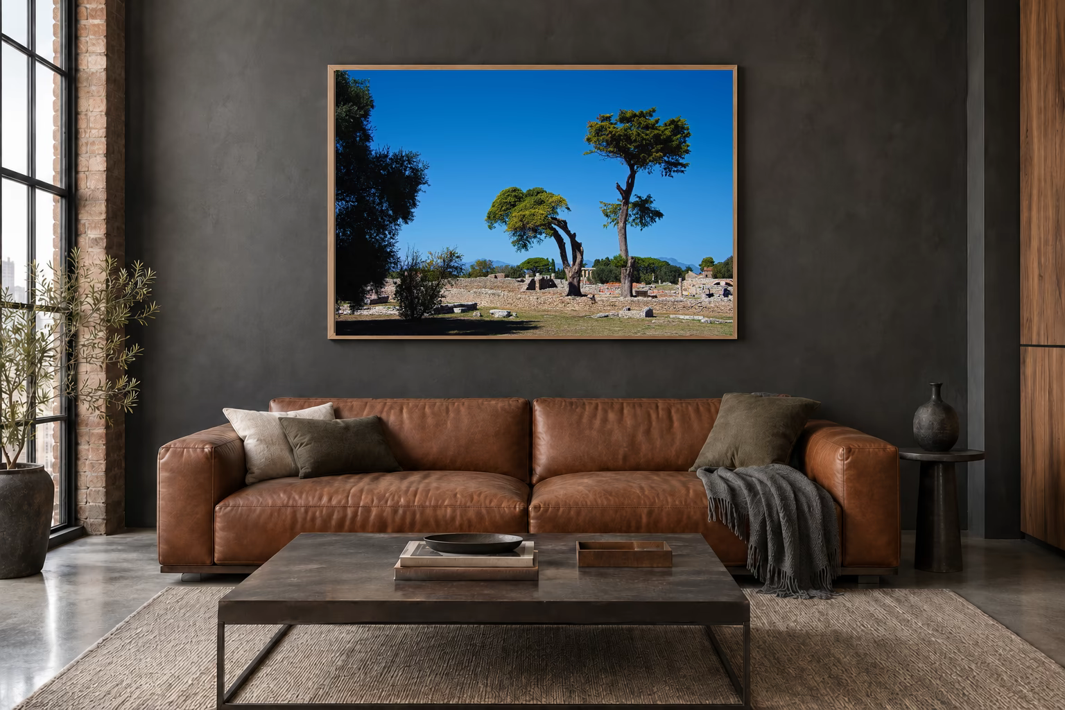 Das Werk an einer dunklen Wand im Loft über einem Ledersofa: Mediterrane Landschaft von Paestum, 120 × 80 cm.
