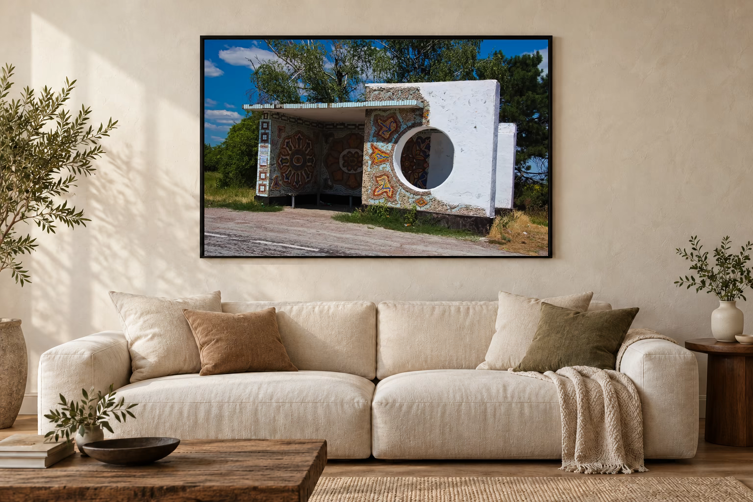 Das Werk an einer hellen Wohnzimmerwand über einem Sofa: Mosaikwand mit rundem Durchbruch im Rahmen, 120 × 80 cm.