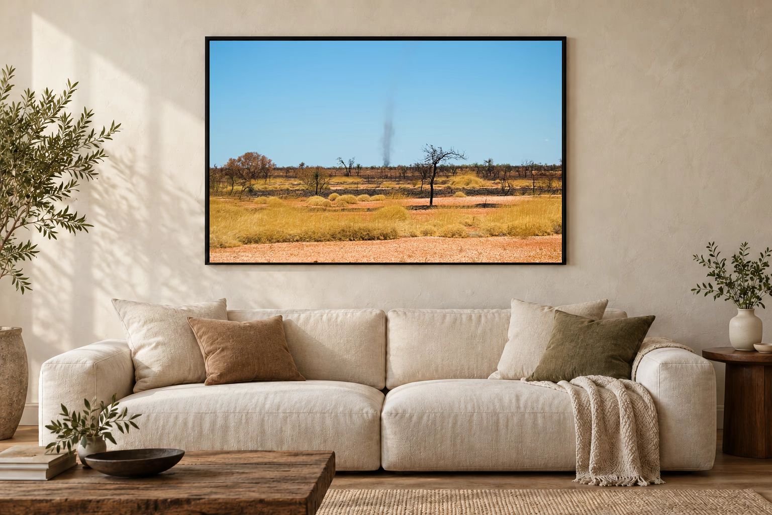 Das Werk an einer hellen Wohnzimmerwand über einem Sofa: Rauchspur im Outback im Rahmen, 120 × 80 cm.
