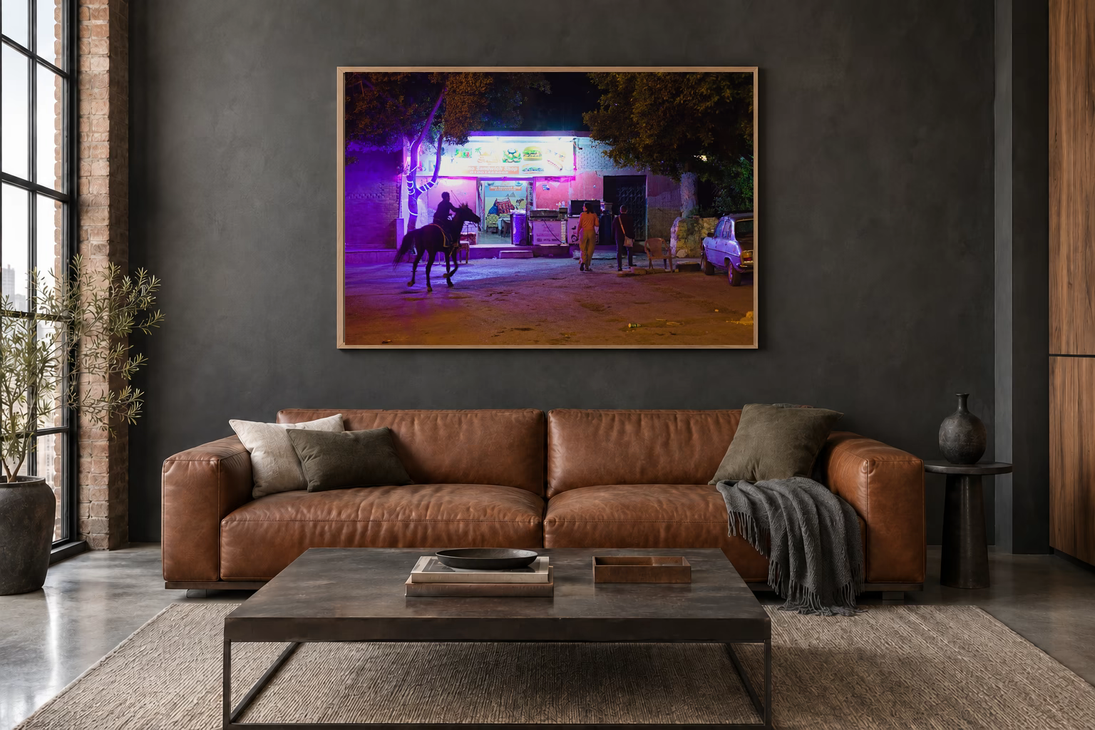 Das Werk an einer dunklen Wand im Loft über einem Ledersofa: Reiter vor dem Nachtimbiss, 120 × 80 cm.