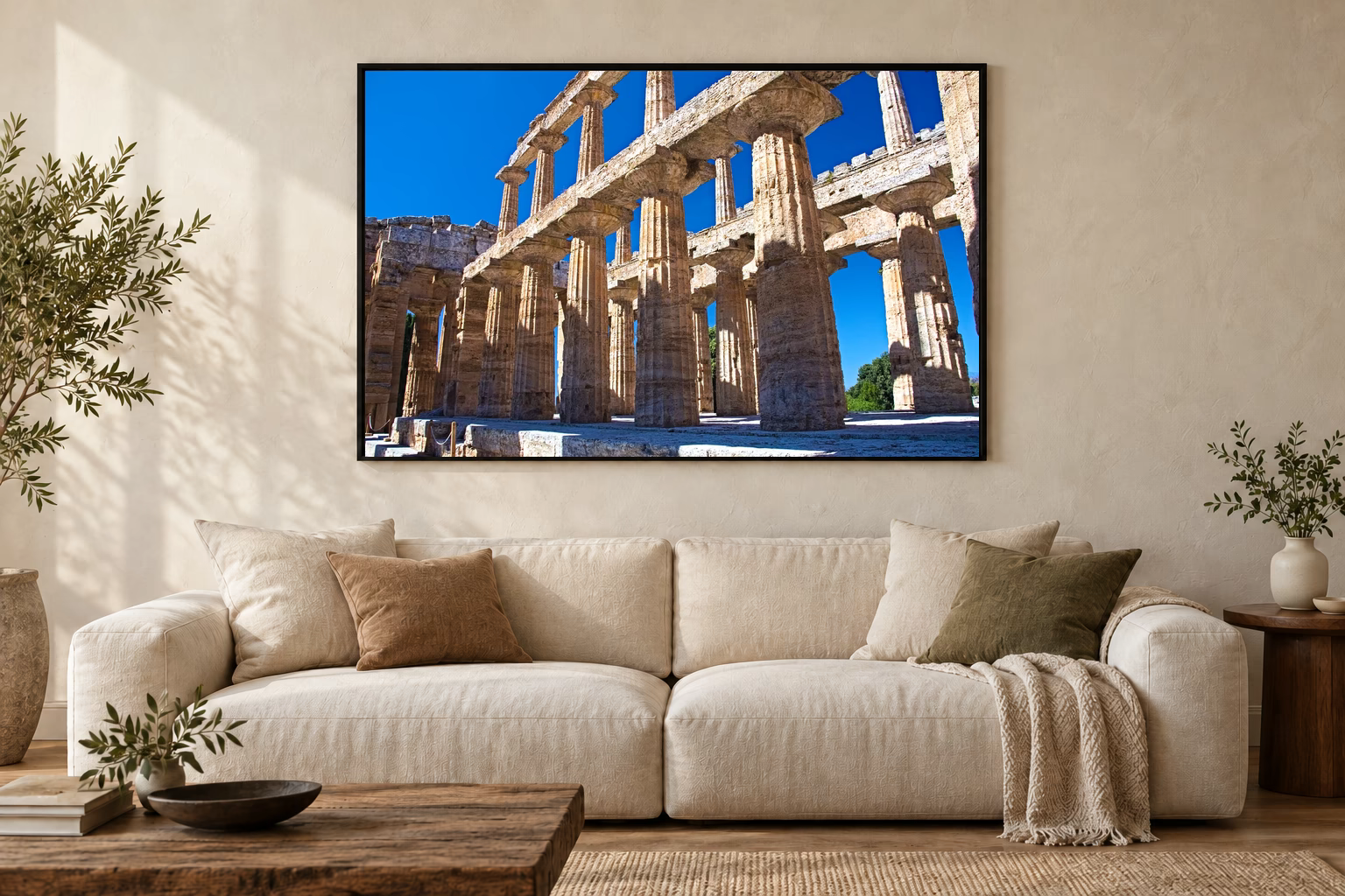 Das Werk an einer hellen Wohnzimmerwand über einem Sofa: Säulenhalle von Paestum im Rahmen, 120 × 80 cm.