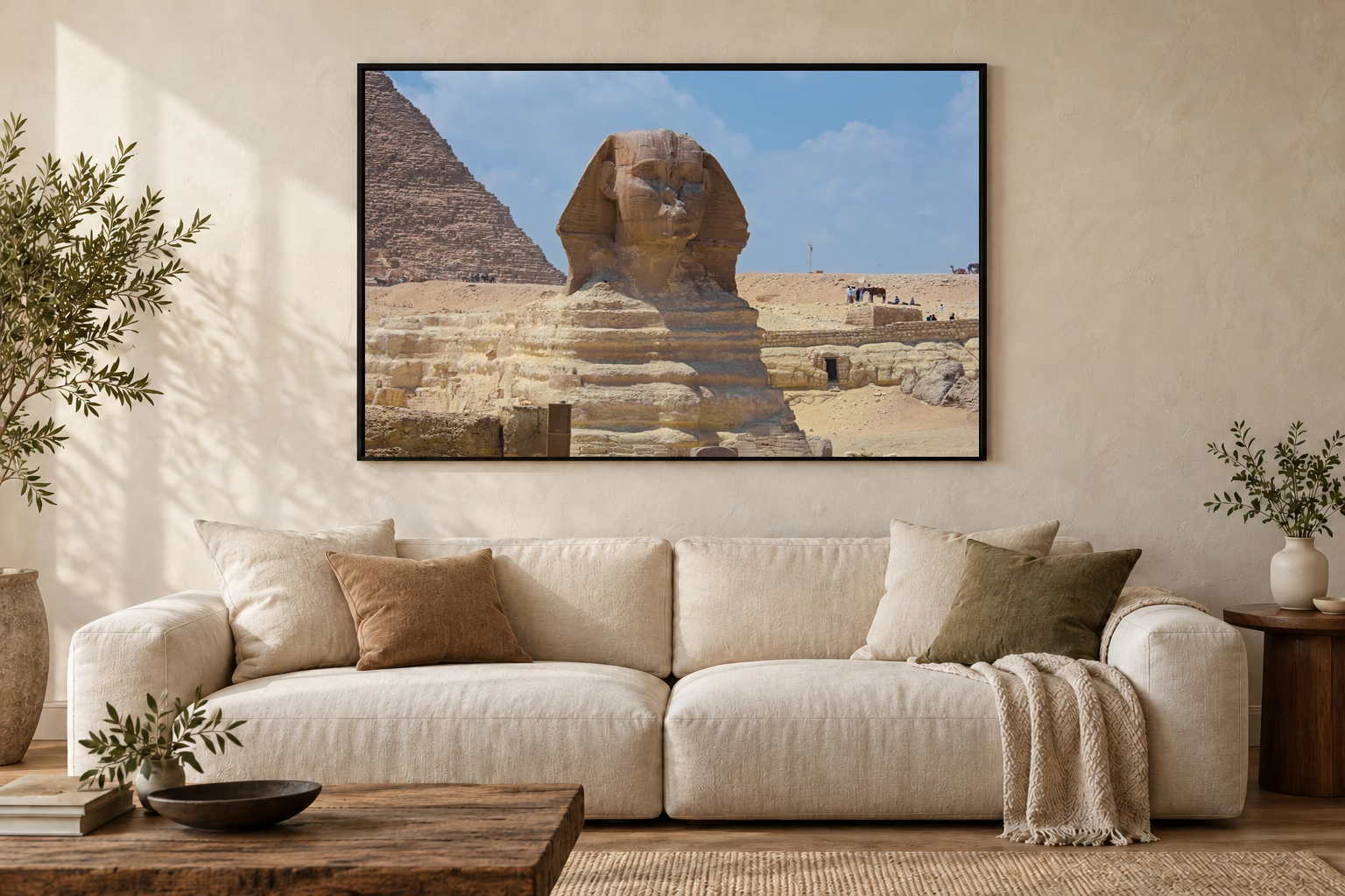 Das Werk an einer hellen Wohnzimmerwand über einem Sofa: Sphinx vor der Pyramide im Rahmen, 120 × 80 cm.