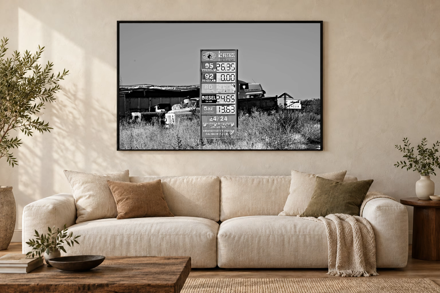 Das Werk an einer hellen Wohnzimmerwand über einem Sofa: Tafel und alte Lastwagen im Rahmen, 120 × 80 cm.