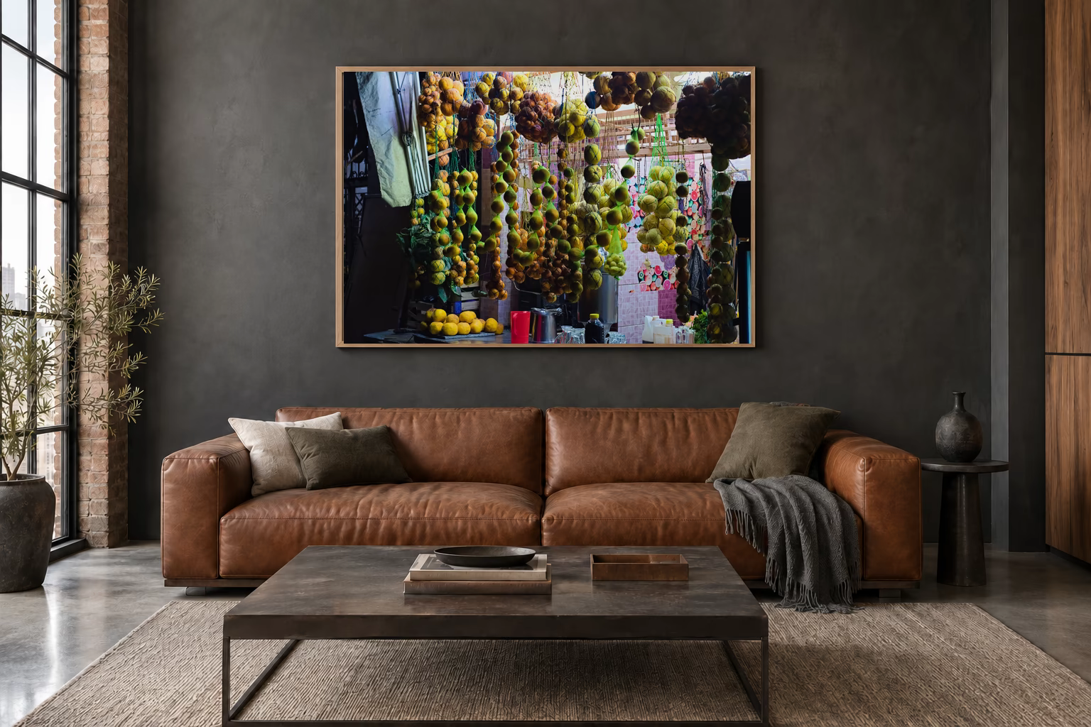 Das Werk an einer dunklen Wand im Loft über einem Ledersofa: Zitrusfrüchte in Netzen, 120 × 80 cm.