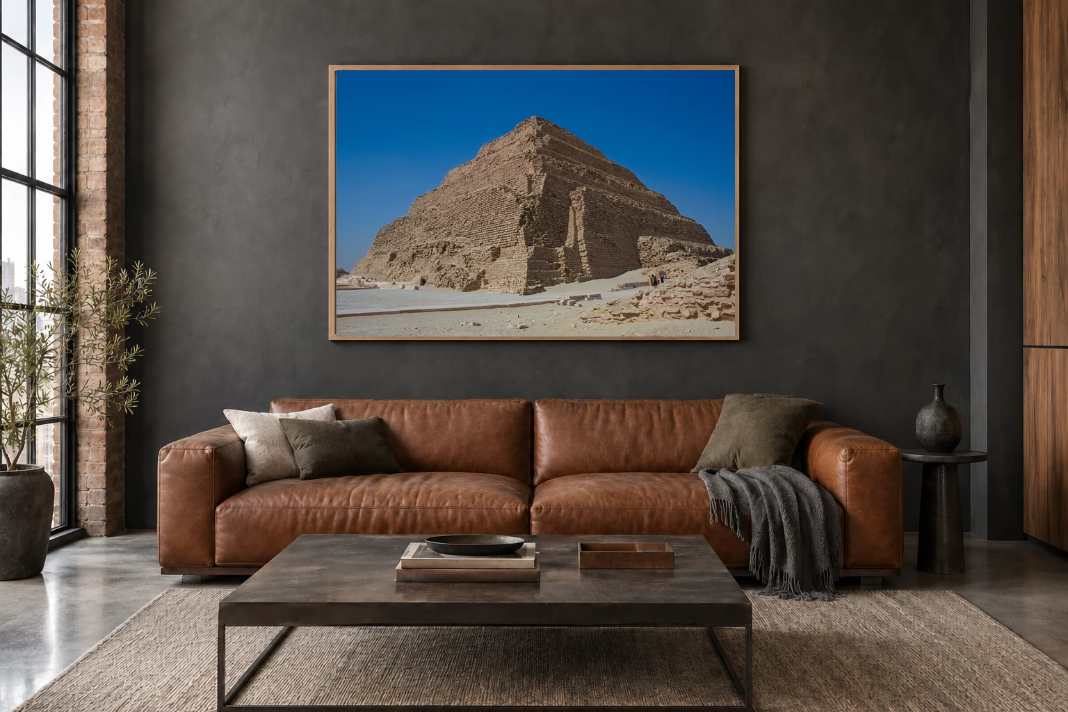 Das Werk an einer dunklen Wand im Loft über einem Ledersofa: Zwei Figuren an der Stufenpyramide, 120 × 80 cm.